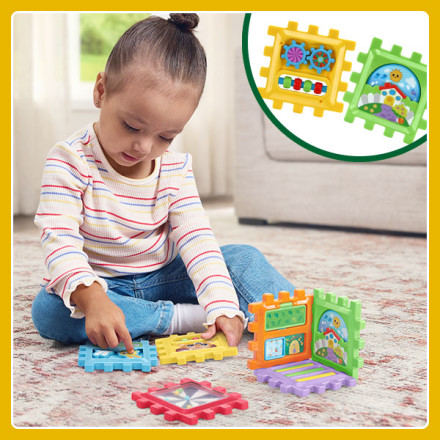 Girl builds a cube by snapping large, colorful puzzle block pieces together.