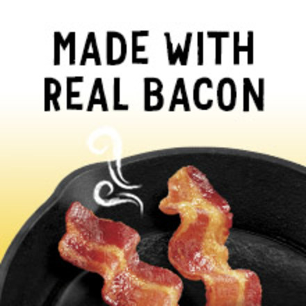 Bacon strips sizzling in a black skillet.