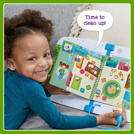 Kid smiles at the colorful illustration of a messy classroom. LeapStart says: Time to clean up!