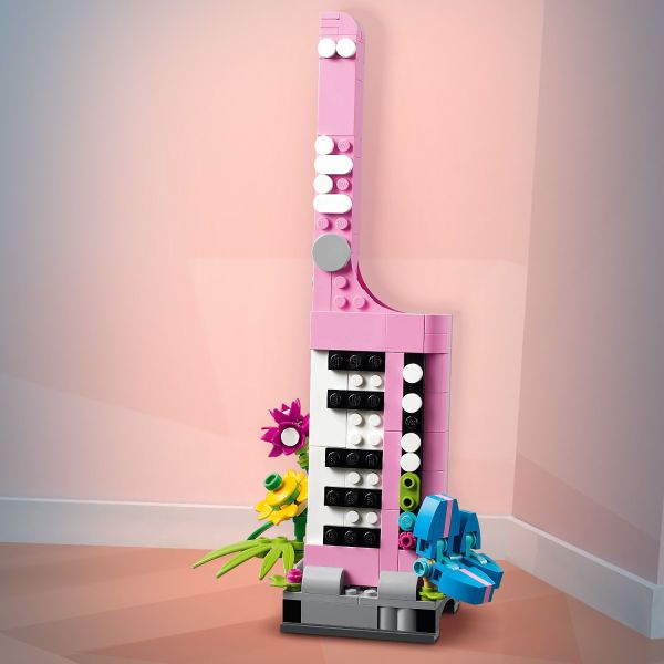 Colorful keytar toy on a stand with flowers.