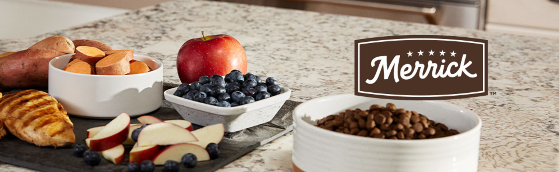 Merrick Pet Care logo on a picture of a counter top with a bowl of dry kibble and a cutting board