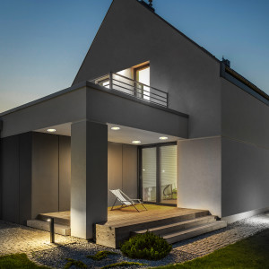 Exterior shot of a home with BR30 LED smart light bulbs turned on and emitting 2700K Soft White-5000K Daylight and RGB.