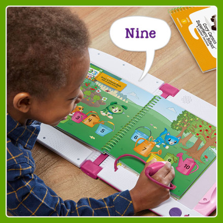 Boy uses stylus to point at brightly colored and numbered water cans in book. LeapStart says: Nine.