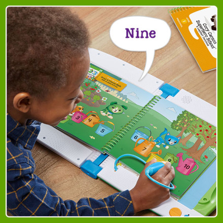 Boy uses stylus to point at brightly colored and numbered water cans in book. LeapStart says: Nine.