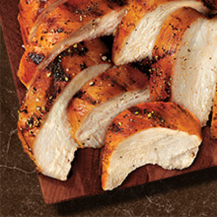 Photograph of cooked and sliced chicken on a cutting board.