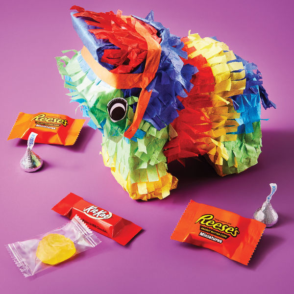 Hershey's Kisses candies, Kit Kat Miniatures bars and Reese's Miniatures cups around a pinata