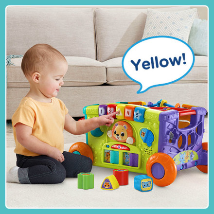 Kid pushes yellow button on green play panel. Toy says Yellow!