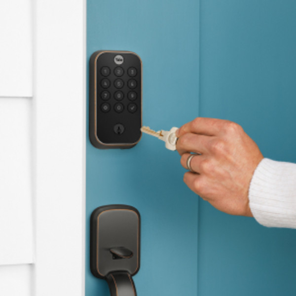 Man unlocking door lock with key