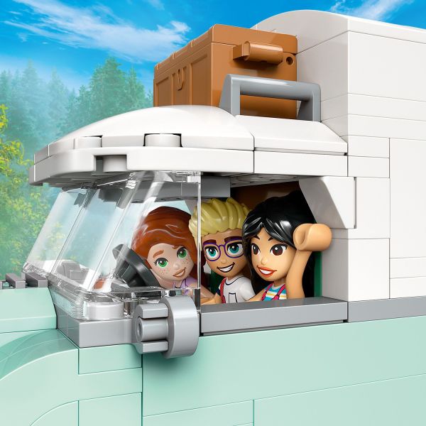 The friends sit in the driver’s cab and steer the van.