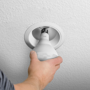 BR30 dimmable led bulb being installed in ceiling recessed can light with E26 base socket.