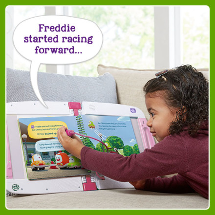 Girl uses stylus to point at words in book. LeapStart says: Freddie started racing forward…
