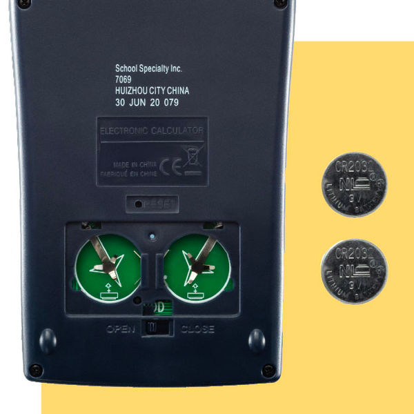 Calculator battery compartment displayed with two button-cell batteries.