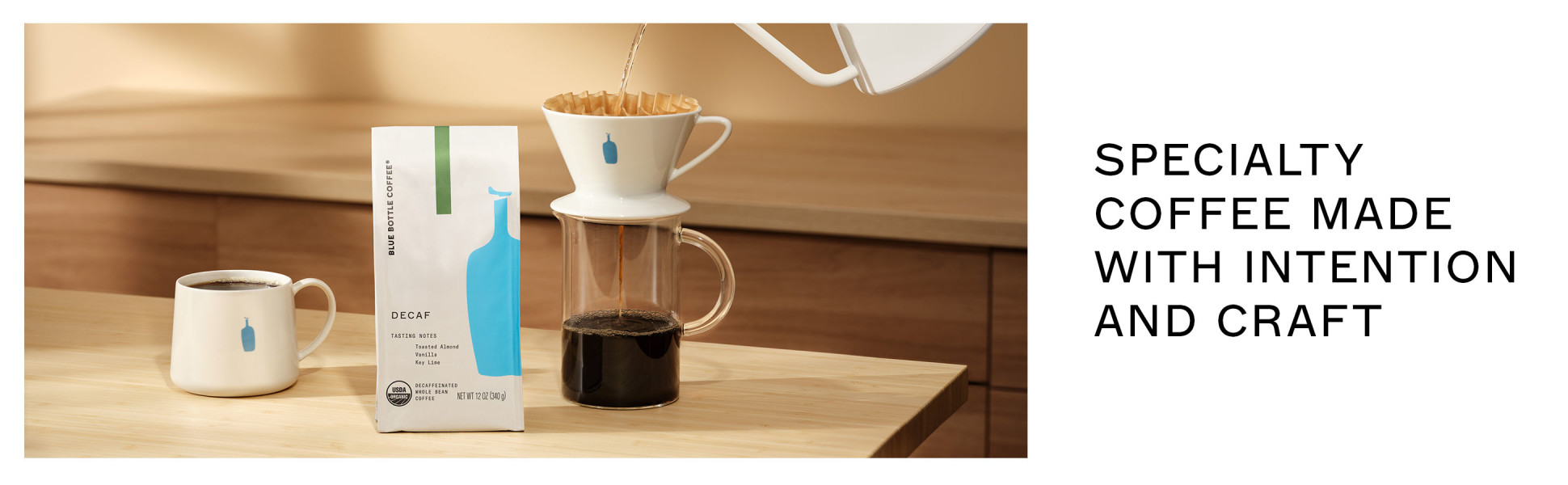 A bag of Decaf, a full mug and a pourover. Specialty coffee made with intention and craft.