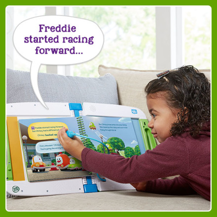 Girl uses stylus to point at words in book. LeapStart says: Freddie started racing forward…