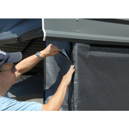 Man securing the doors of the enclosure kit.