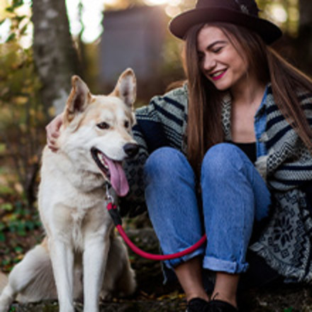 Woman sitting next to dog outside