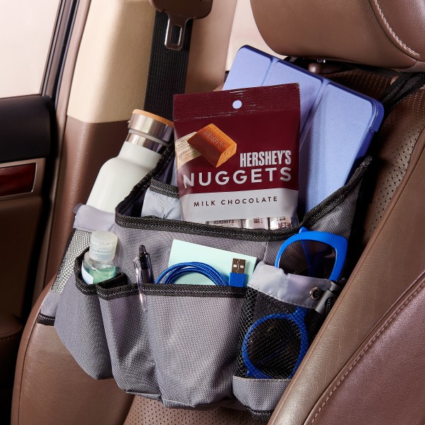 A car organizer full of travel essentials and a bag of HERSHEY'S NUGGETS candies