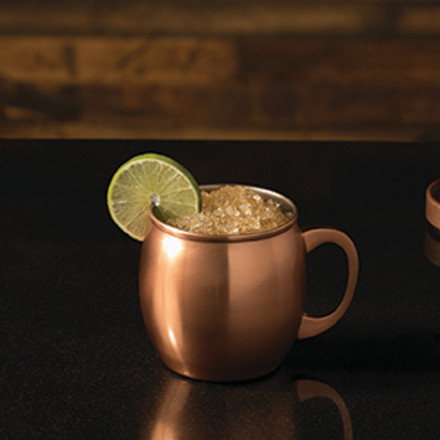 Kentucky Mule in a copper mug with a lime wheel garnish sitting on a dark counter