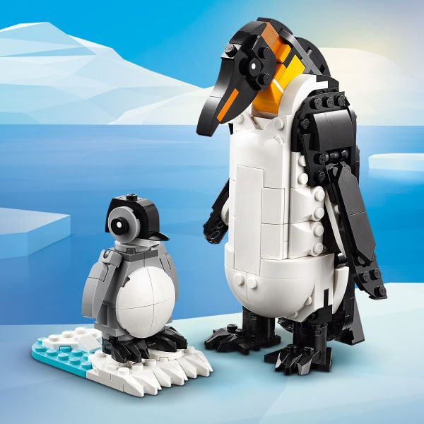 Penguin toy with its chick on a patch of ice and water.